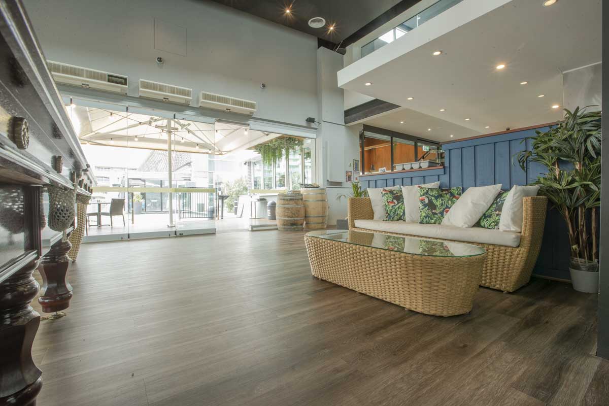 Dark hybrid flooring in a Port Melbourne restaurant lounge area opening onto a terrace