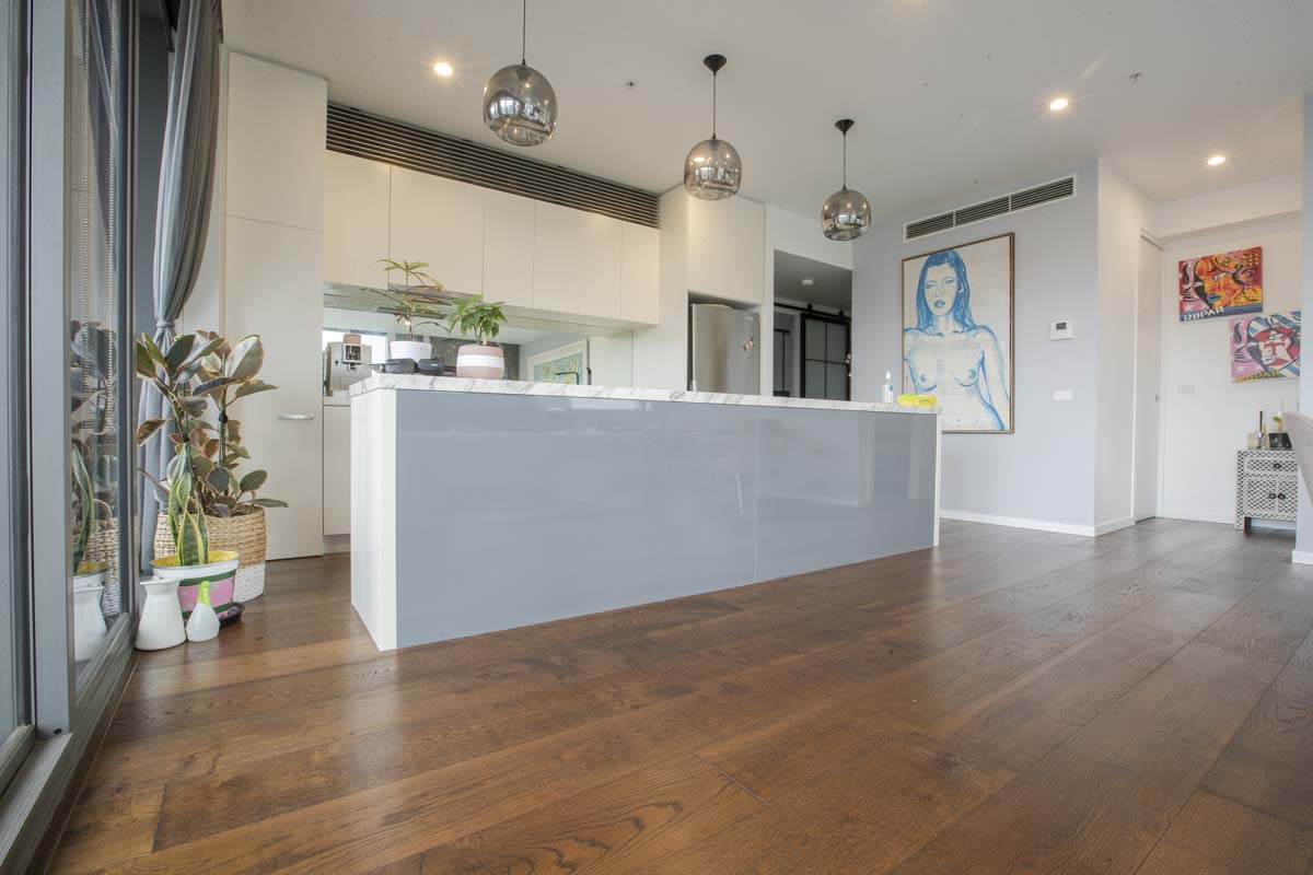 Mocha Brown engineered oak flooring through an open plan apartment kitchen and living area