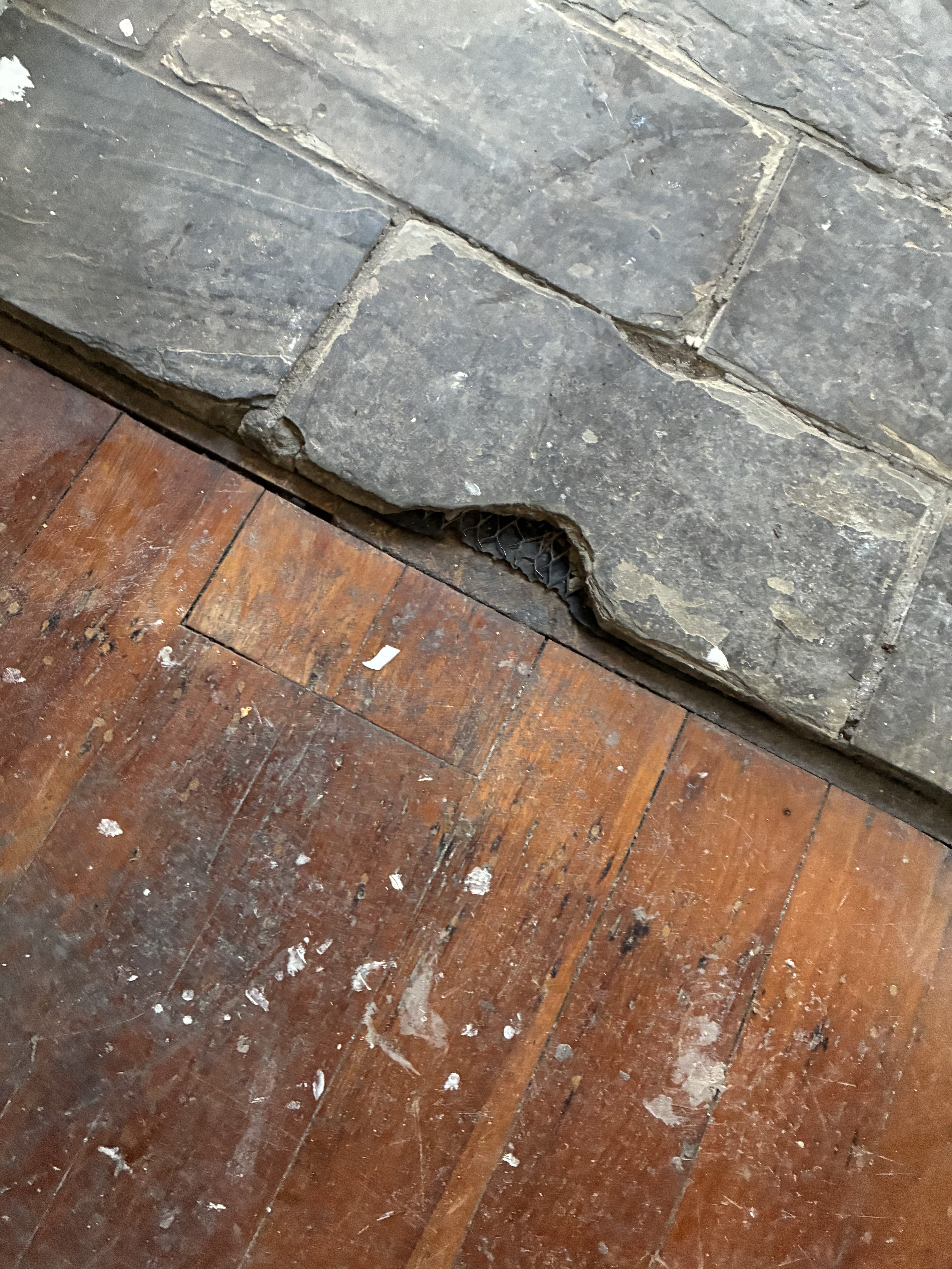Uneven join between old floorboards and slate hearth before renovation, Caulfield North