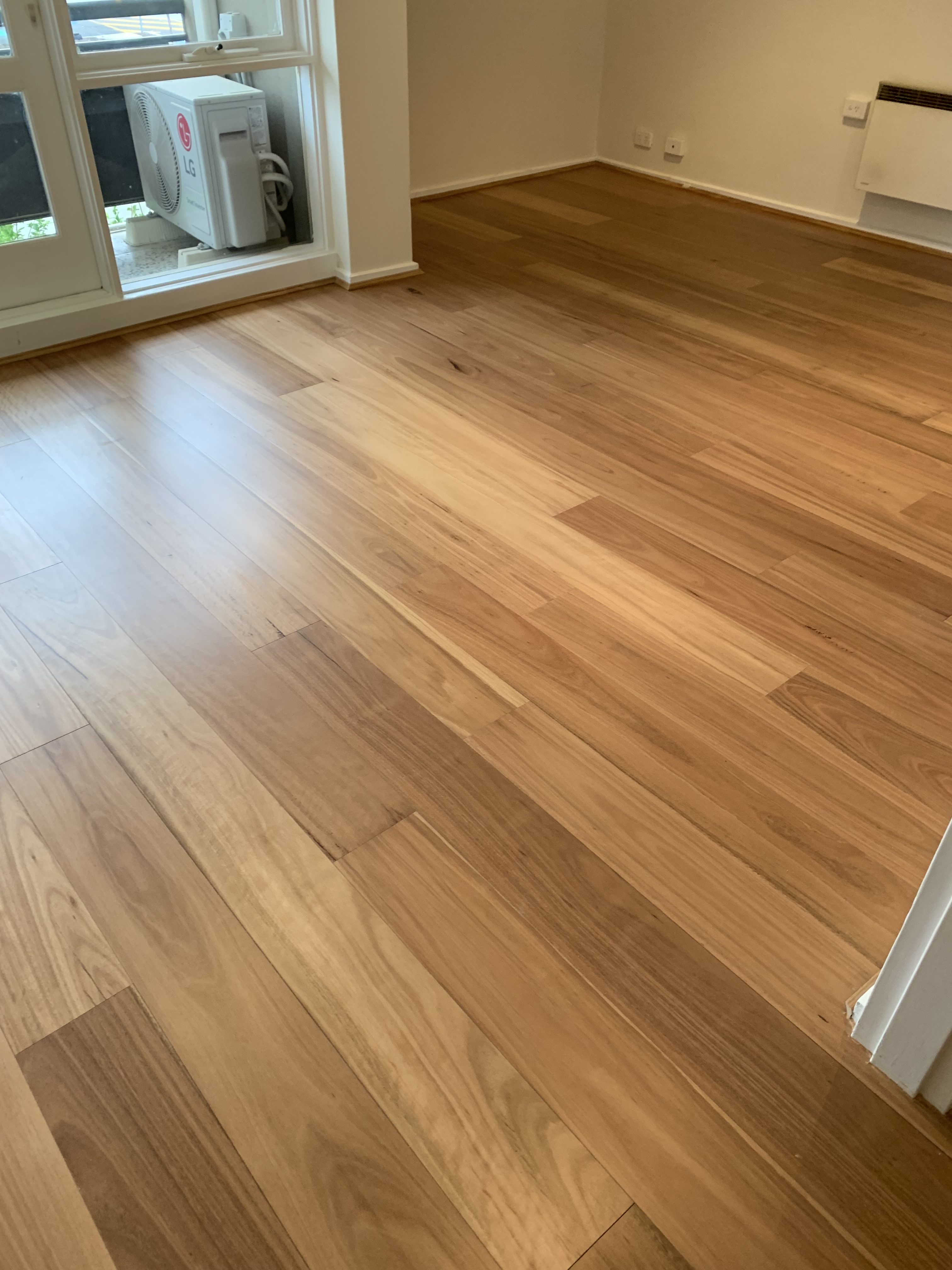 Blackbutt timber flooring across a full room in a Hampton home with skirting and window detail